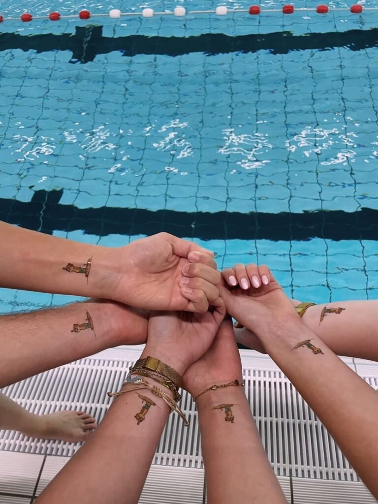 Sei polsi sul bordo della piscina, ognuno con lo stesso tatuaggio temporaneo personalizzato
