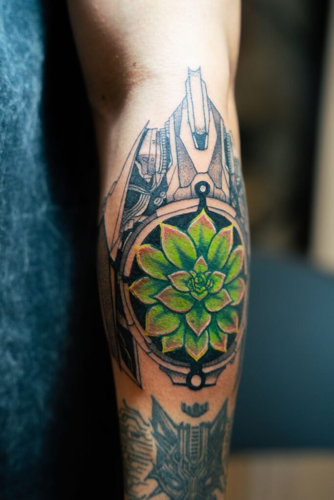 Tatuaggio mandala geometrico con un fiore verde al centro su un polpaccio