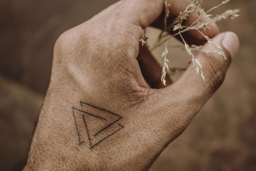 Piccolo triangolo come tatuaggio minimal sul dorso di una mano